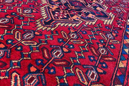 Detail of a Hamadan runner: red ornamental pattern with blue and beige accents