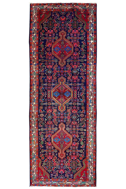 Rectangular oriental runner rug with border and all-over ornaments in blue and red