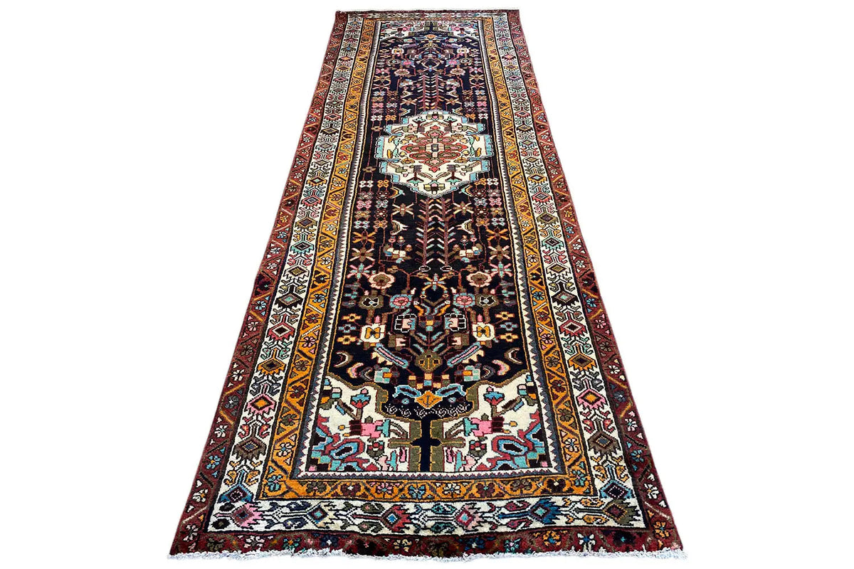 Oriental runner rug with long side borders, a dark base, and a central medallion pattern