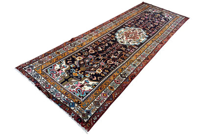 Hamadan rug with an ornamental medallion pattern, multicolored border, and dark background