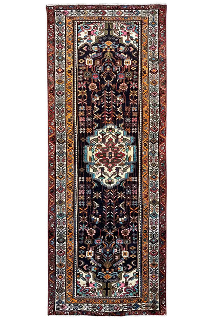 Rectangular Oriental rug runner with a dark background, a central medallion, and borders