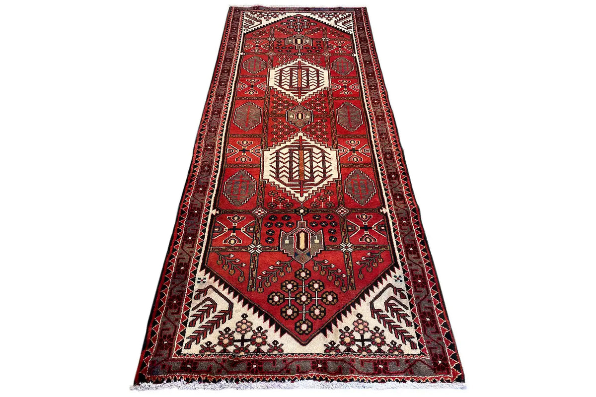 Hamadan runner with a red Oriental rug pattern, central medallion, diagonal view
