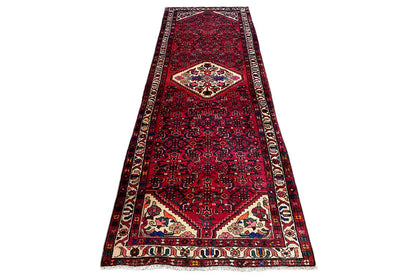Hamadan runner in a narrow layout: red ground, central medallion, and borders along the edges
