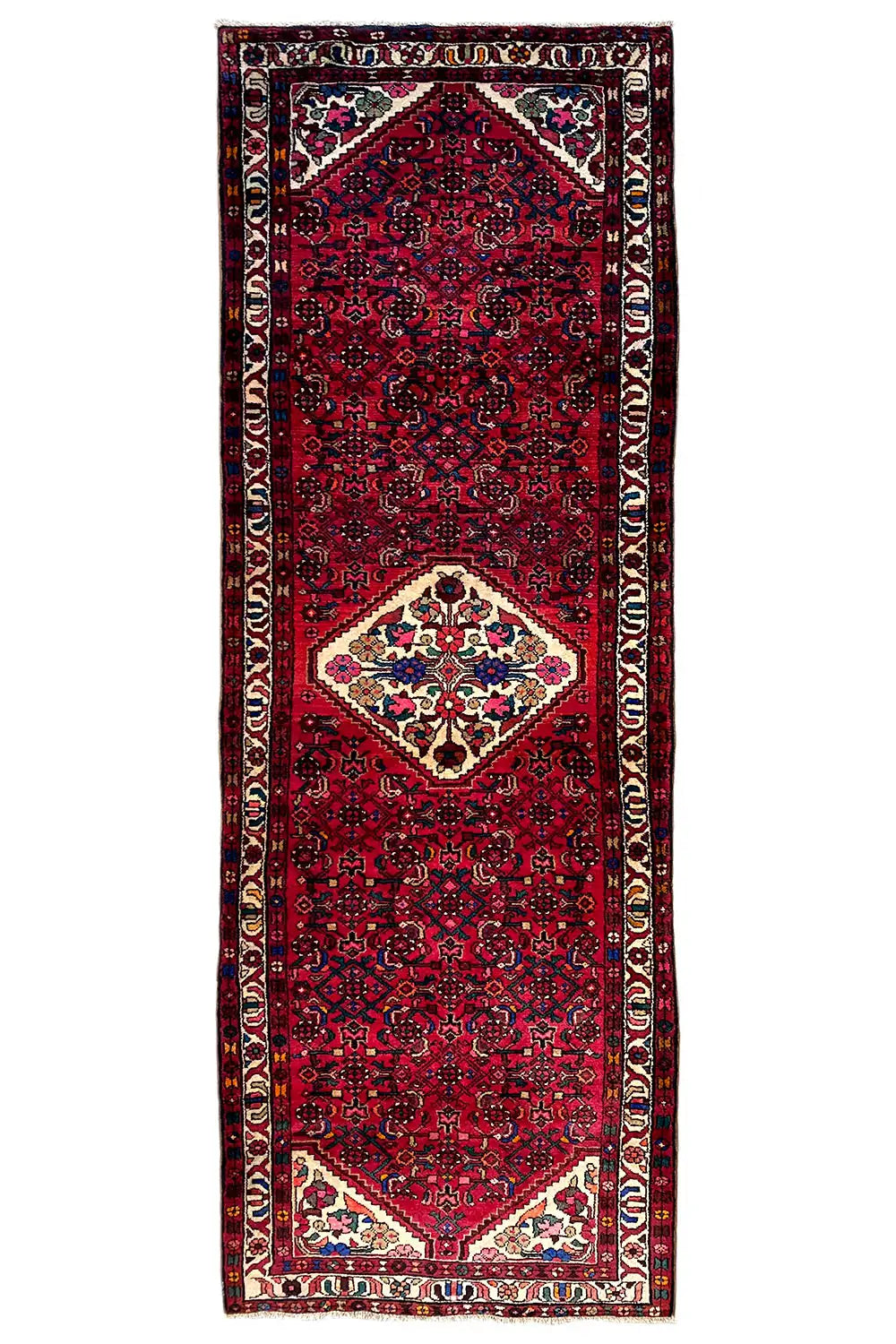 Hamadan runner in a still image: red field pattern, white medallion, multicolored border trim