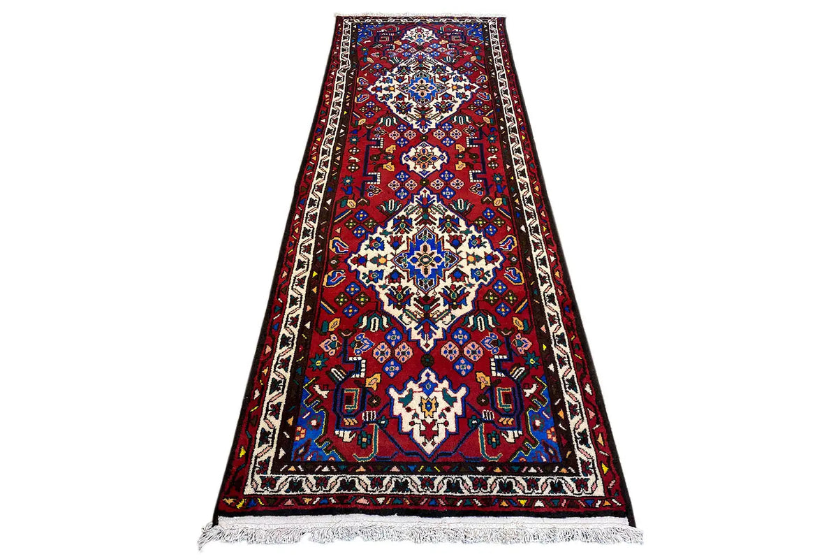 Hamadan runner with a red field, large central pattern in blue and white, fringe