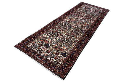 Runner rug with a symmetrical central pattern and decorative border in dark colors