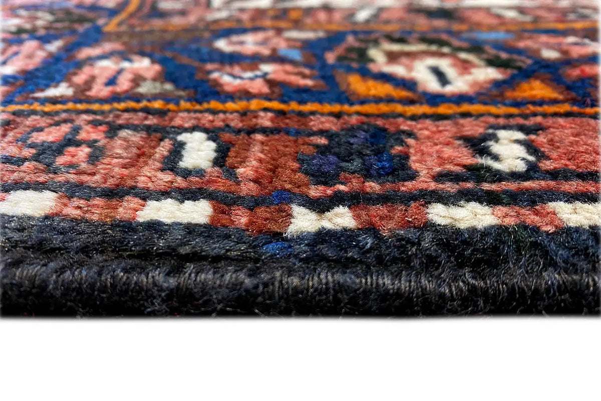 Detail of the carpet edge with a pile texture and multicolored ornaments, dark background