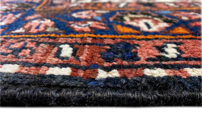 Detail of the carpet edge with a pile texture and multicolored ornaments, dark background