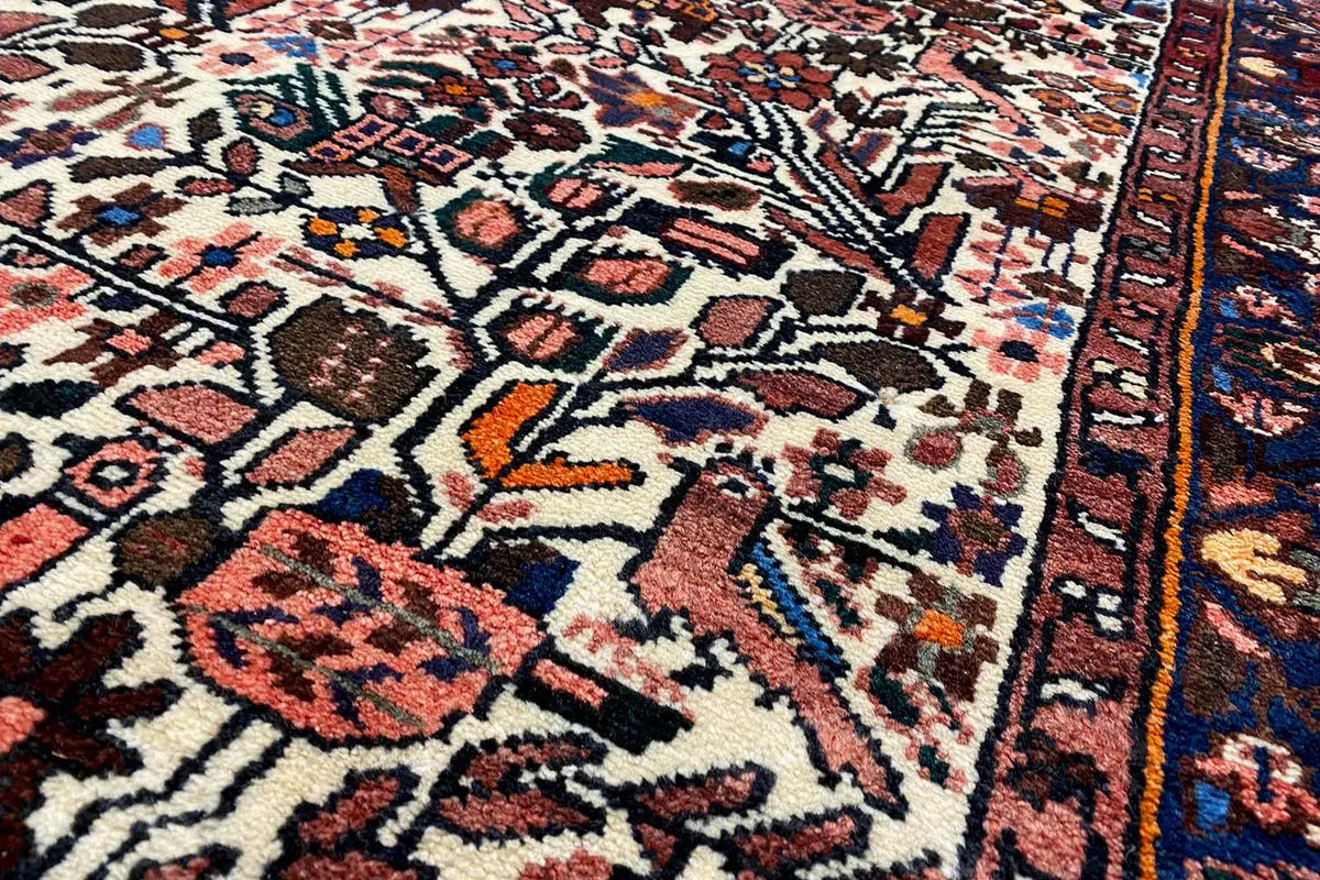 Runner rug with a geometric mix of red, blue, and beige ornaments on a light background