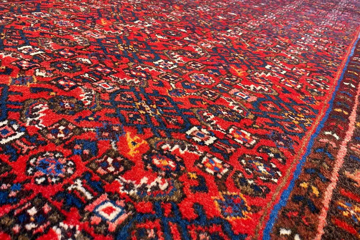 Close-up: detailed red and blue ornamental pattern on a runner rug