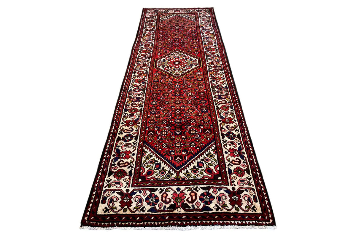 Red carpet runner with central medallion, wide border, and fringe