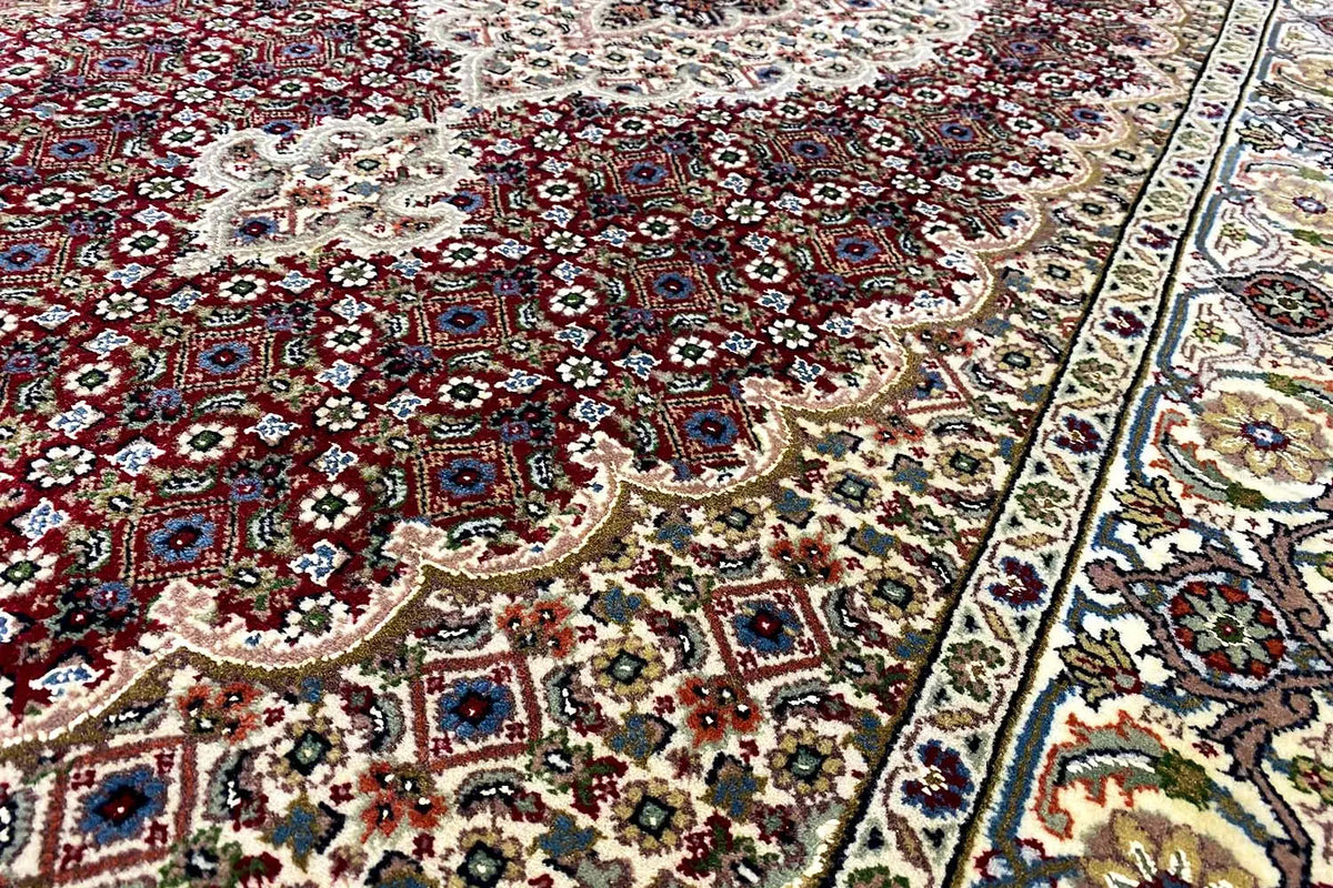 Rug with an ornamental pattern in red, cream, and blue, as well as a wide border design
