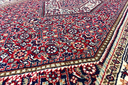 Rug with a red, blue, and cream-colored pattern, detailed view of the edge.