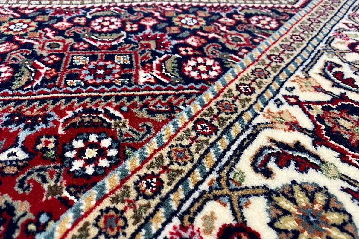 Bidjar oriental rug, close-up: red and blue medallion pattern on a light background