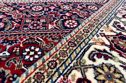 Bidjar oriental rug, close-up: red and blue medallion pattern on a light background