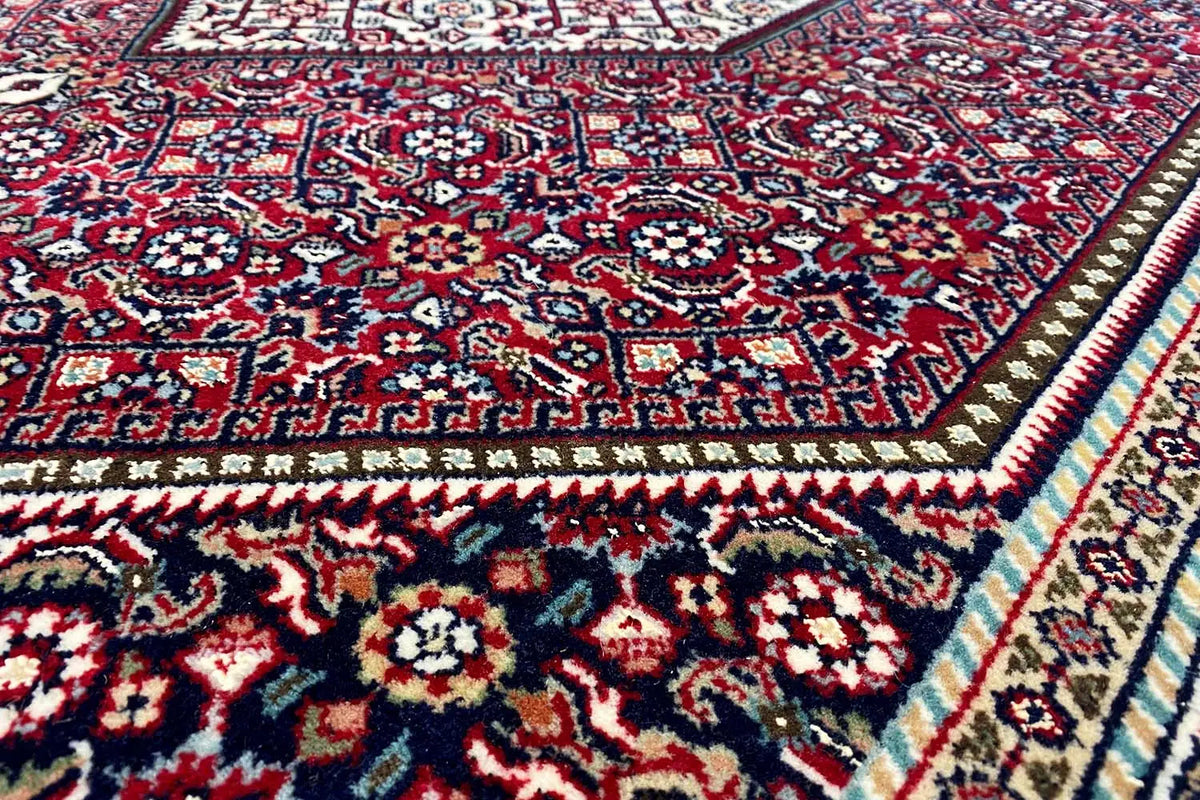 Close-up of a Bidjar carpet: geometric ornaments in red, blue, and dark blue
