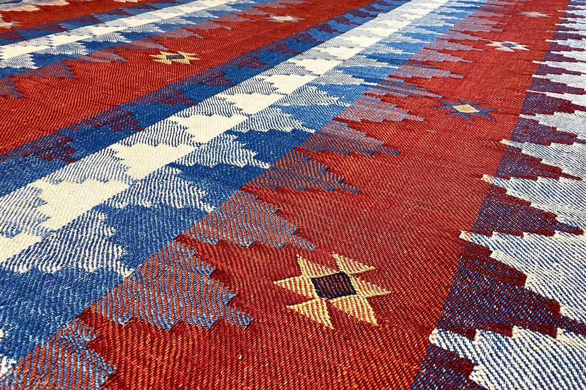 Carpet with a kilim pattern featuring red, blue, and cream areas, as well as woven-in symbols