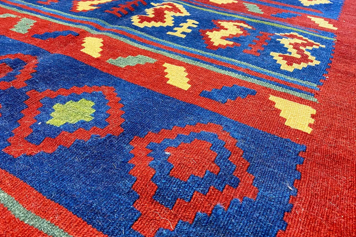 Kilim rug with a blue background and multicolored geometric patterns