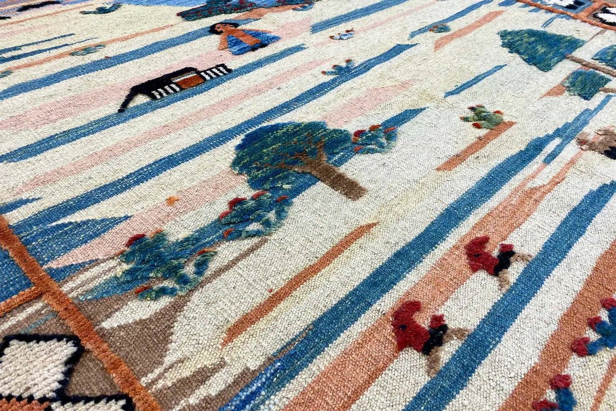 Close-up view of a kilim pattern with figures, trees, and a blue striped border