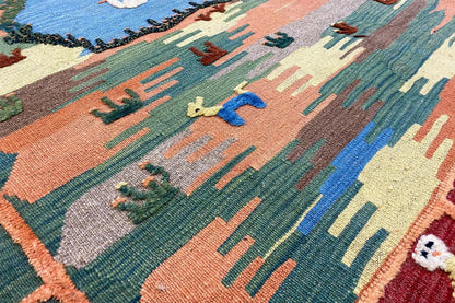 Close-up: Kilim with plant and animal motifs in blue, green, orange, and beige