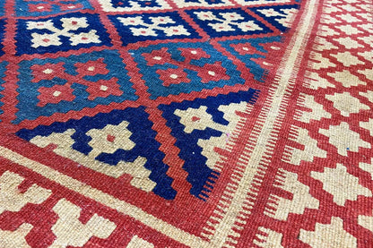 Kilim rug with geometric patterns in blue, red, and cream, close-up of the surface