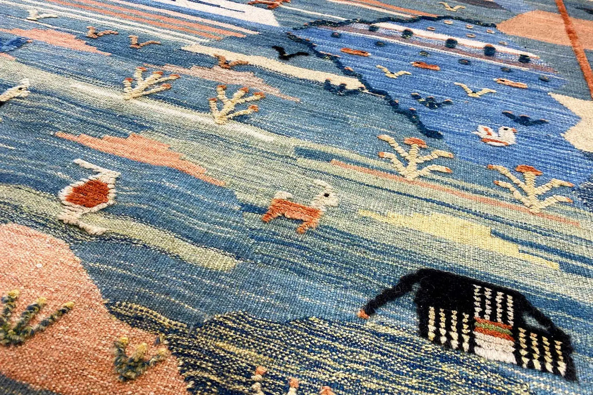 Kilim rug detail with a blue background and animal and ornamental motifs