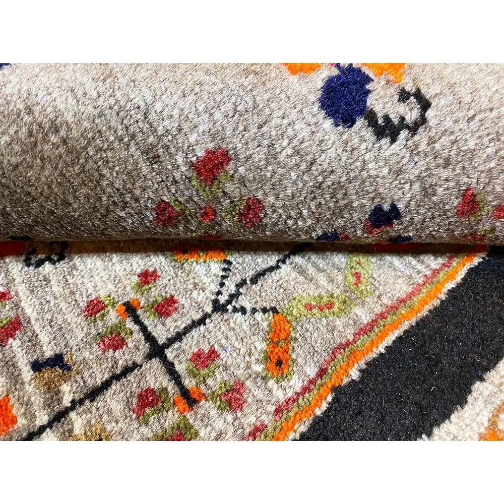 Carpet detail: gray pile surface with colorful patterns and a dark border strip