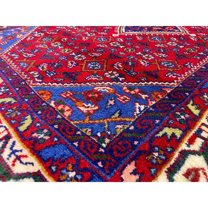Oriental rug with a red background, blue ornamental pattern and border, rectangular