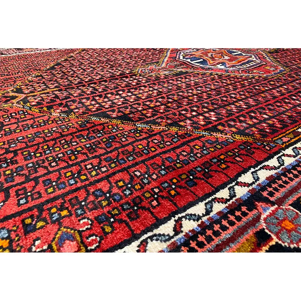 Hamadan rug with a red background, geometric pattern, and blue/white/beige border