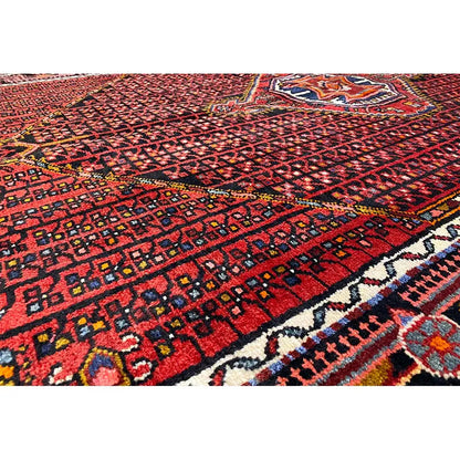 Hamadan rug with a red background, geometric pattern, and blue/white/beige border