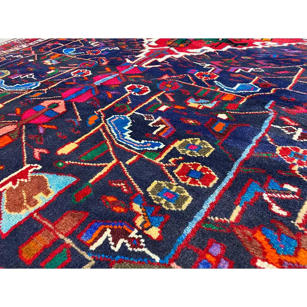 Close-up of a dark blue Hamadan rug with a colorful diamond and medallion pattern.