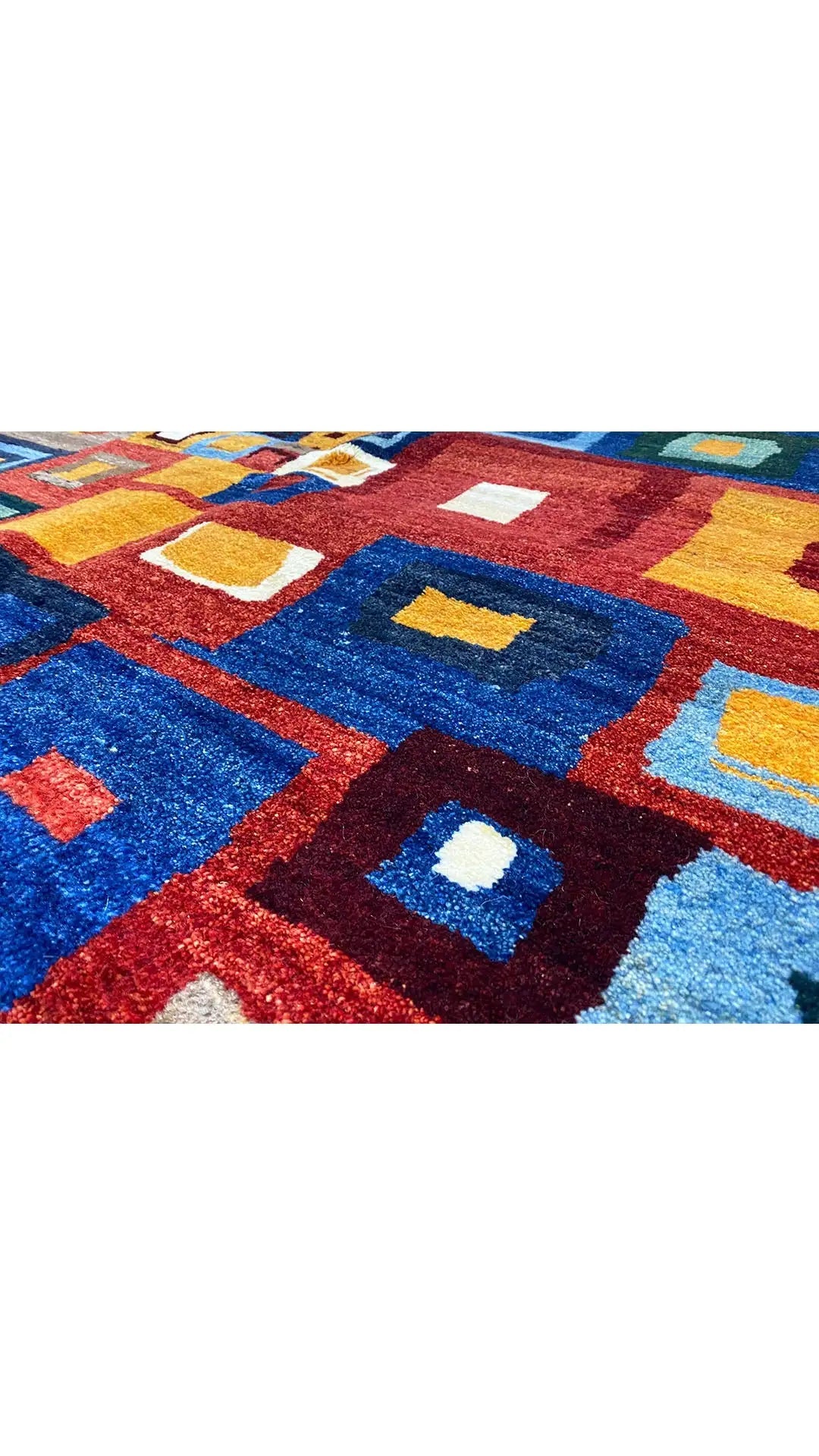 Gabbeh rug (200x151 cm): close-up with a geometric pattern in red, blue, and yellow.