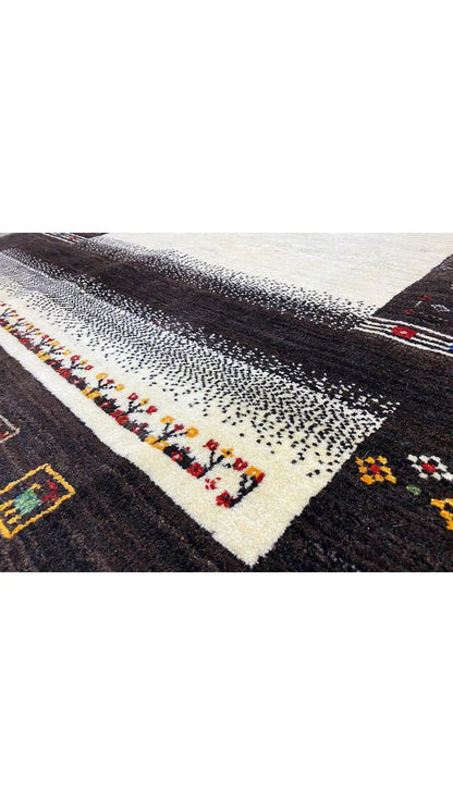 Gabbeh rug: dark brown pile with a cream-colored stripe and colorful motifs