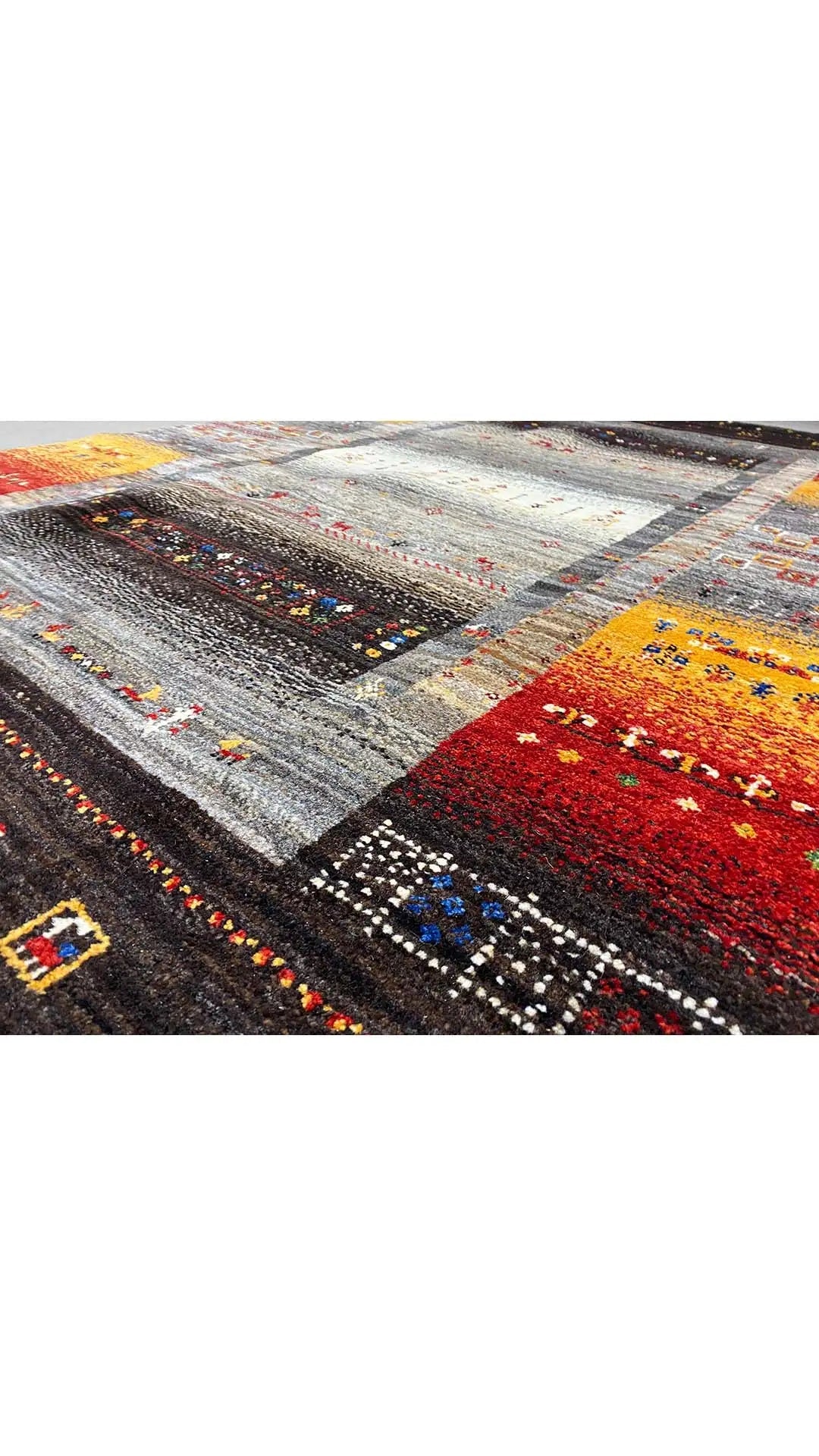 Gabbeh rug with a multicolored pattern in gray, black, red, and yellow
