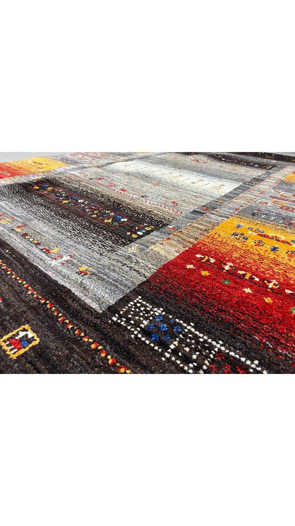 Gabbeh rug with a multicolored pattern in gray, black, red, and yellow
