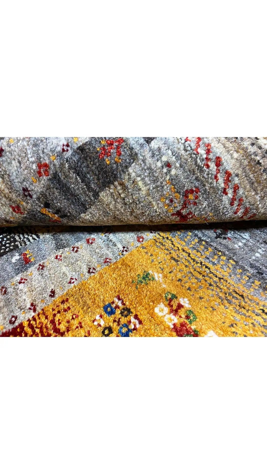 Carpet detail with muted gray tones, a yellow field, and red ornamental motifs