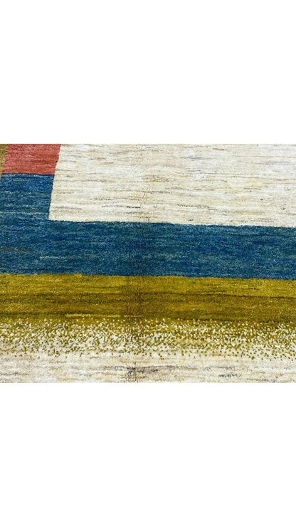 Gabbeh rug with an abstract striped pattern in blue, gold, and beige, right edge close-up.