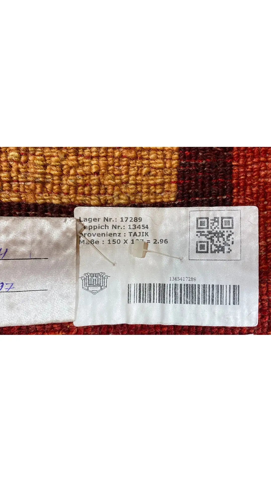 Gabbeh rug detail with a label on the edge, blue-brown pattern