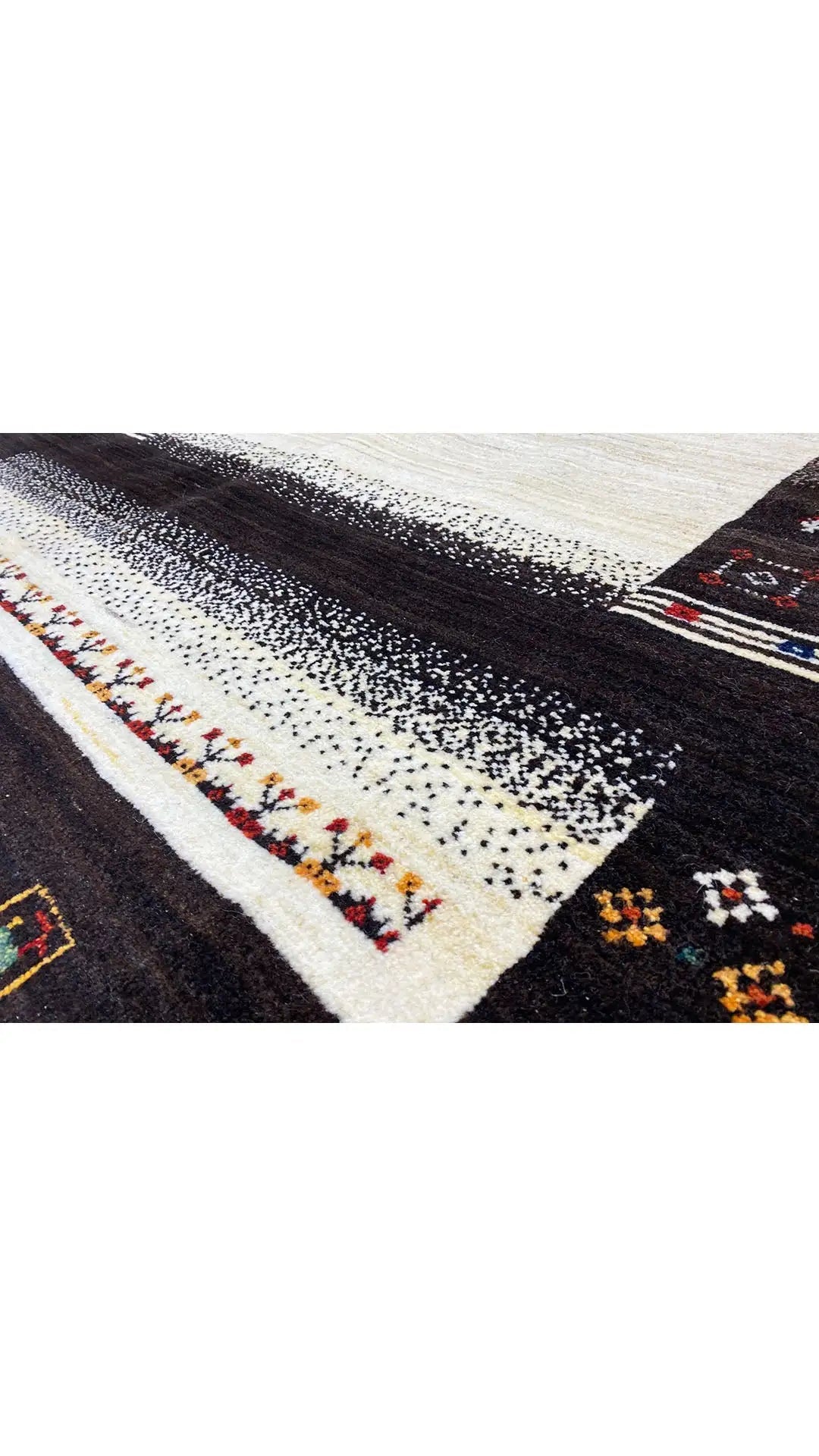 Gabbeh rug with dark brown pile, cream-colored stripes, and multicolored patterns