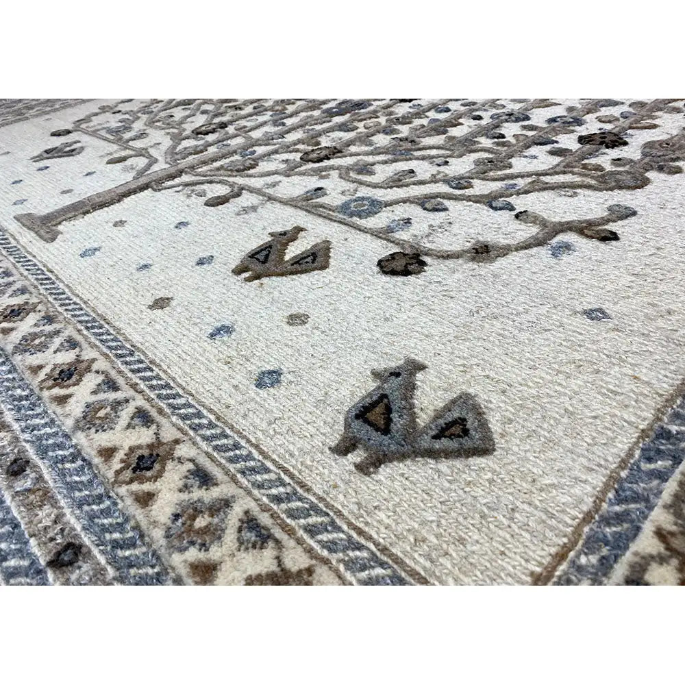 Rug with a light base and a decorative pattern in blue and dark brown, with a decorative border