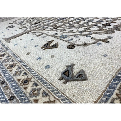 Rug with a light base and a decorative pattern in blue and dark brown, with a decorative border