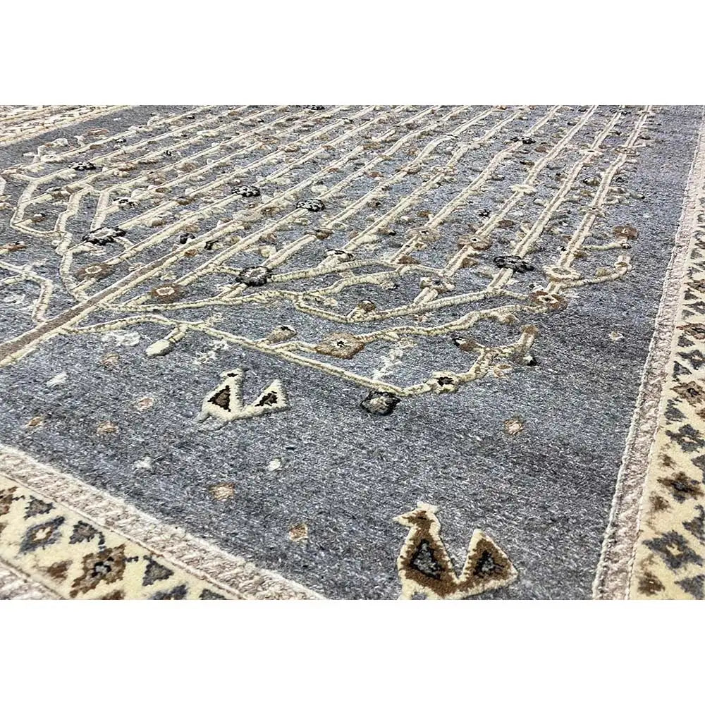 Blue-gray rug with a gold-colored ornamental pattern and geometric border