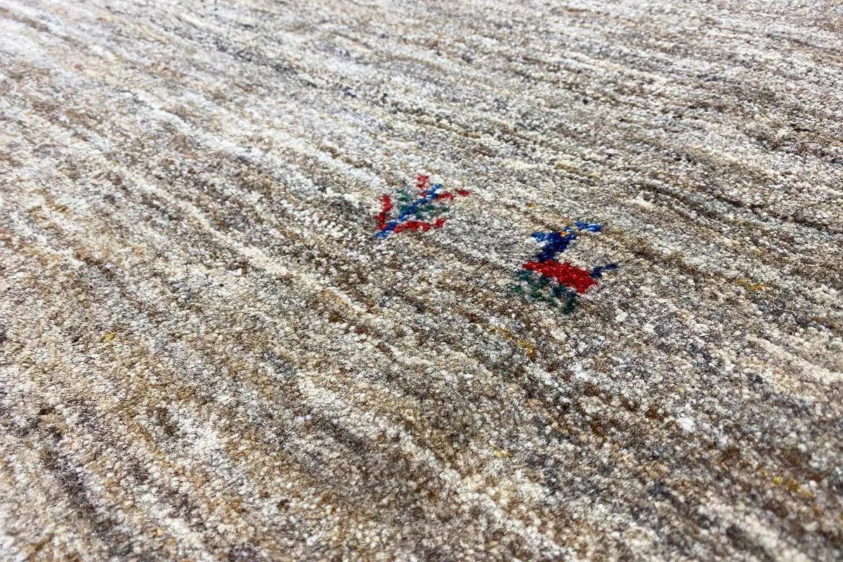 Gabbeh rug: light beige mottled pile with small blue-red pattern elements