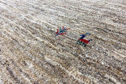 Gabbeh rug: light beige mottled pile with small blue-red pattern elements