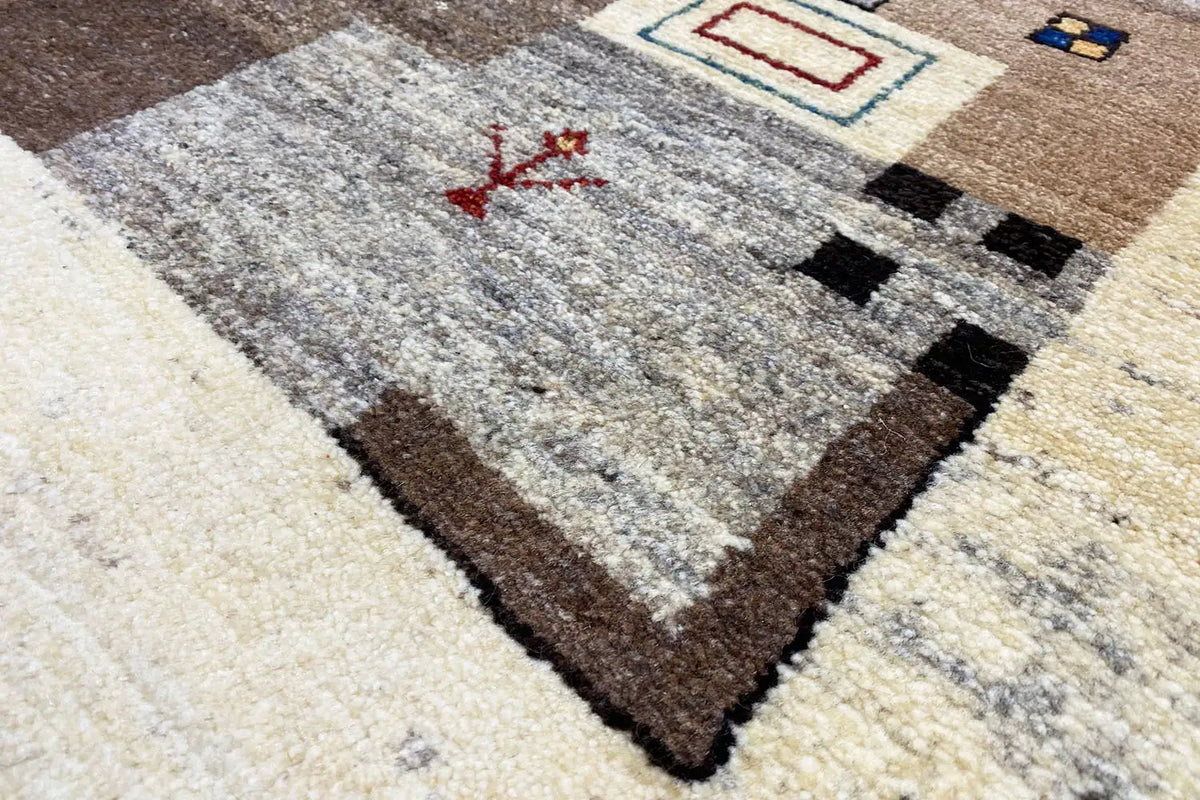 Light gray Gabbeh rug with a red design, black decorative band, and brown border