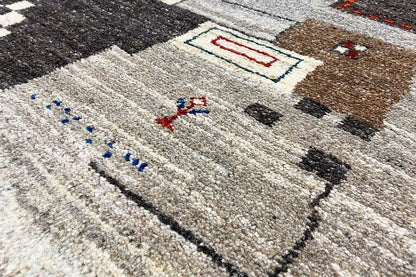 Gabbeh rug with a beige pile and multicolored geometric patterns, close-up.