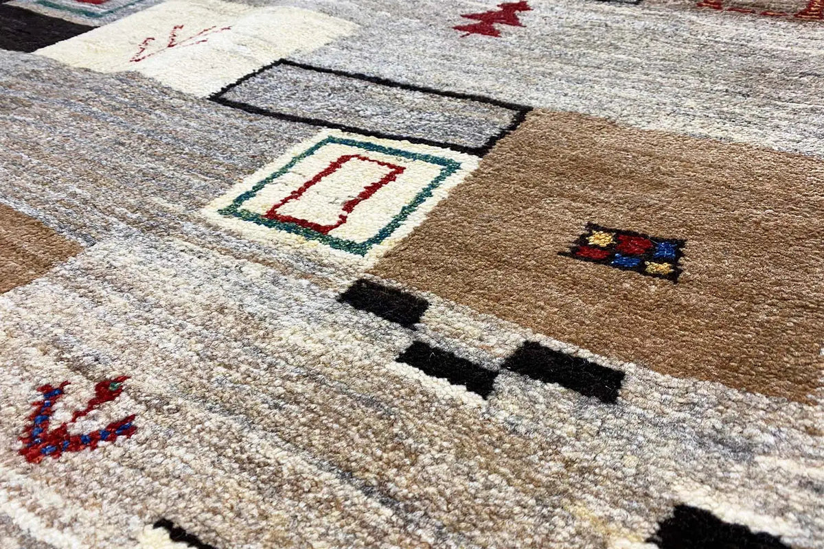 Gabbeh rug: close-up with geometric motifs in beige, black, and red