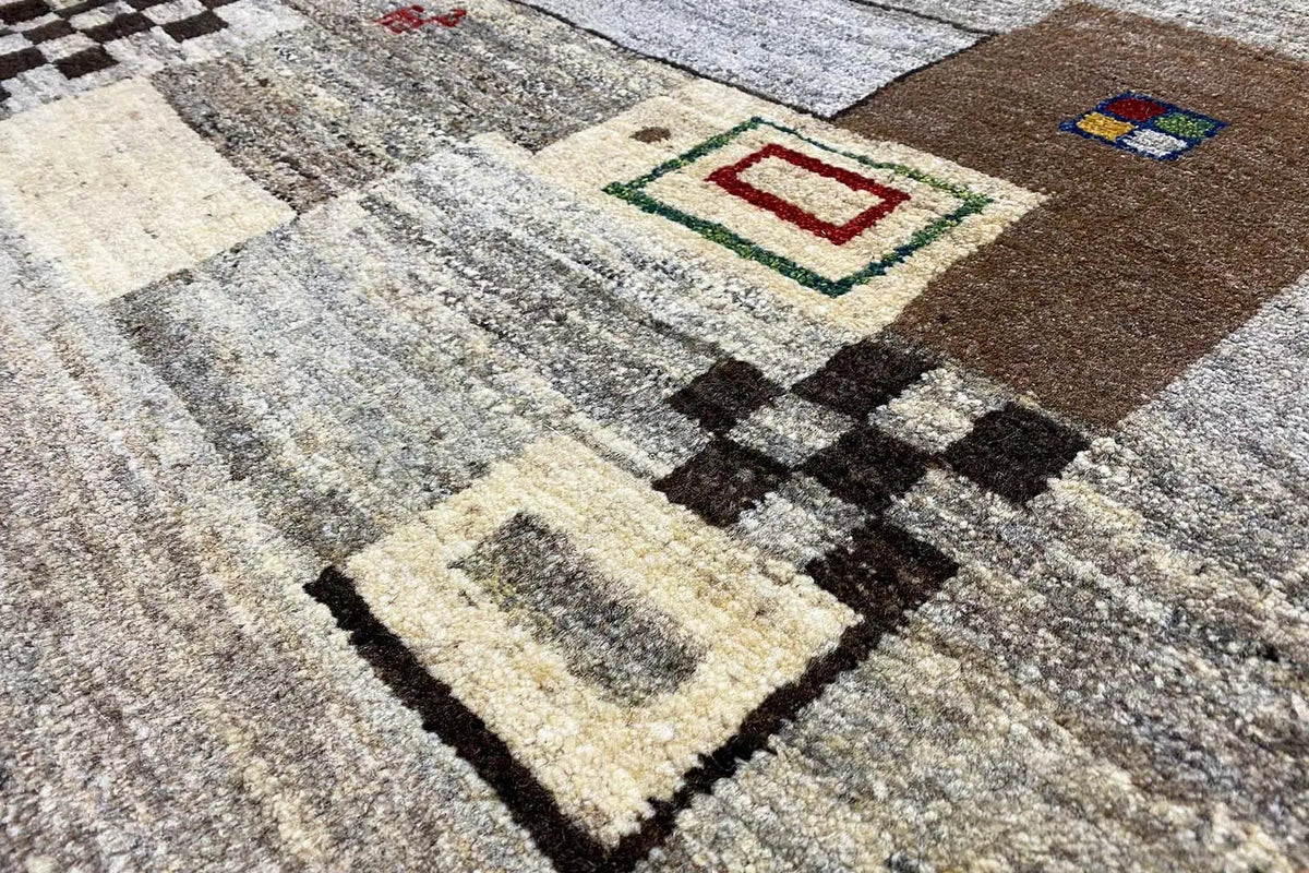 Close-up of a Gabbeh rug: pattern of squares, diamonds, and border in brown, beige, and black