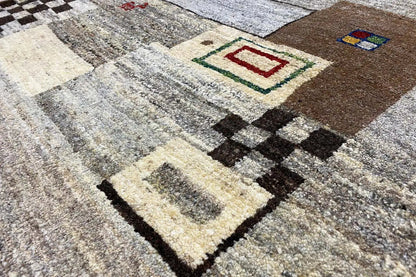 Close-up of a Gabbeh rug: pattern of squares, diamonds, and border in brown, beige, and black