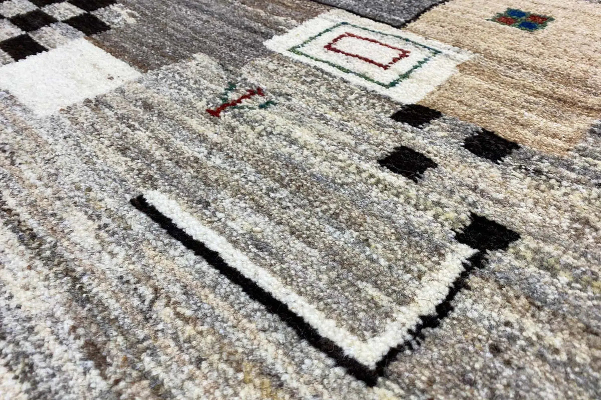 Gabbeh rug, close-up with a gray background and geometric pattern in beige, black, and red